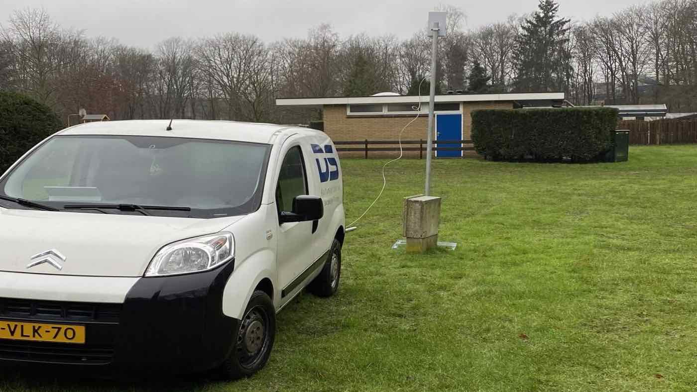 Bedrijfsbus van Digisens op een vakantiepark, naast een mast met een wifi-accesspoint